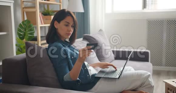 女孩在家用笔记本电脑上网购物慢动作视频的预览图