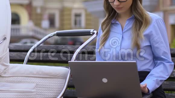 年轻妇女在手提电脑工作时照顾新生儿单身母亲就业视频的预览图