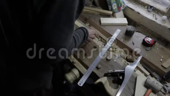 男木匠把木板贴在松木架子上用锯条测量是否合适并加以标记视频的预览图
