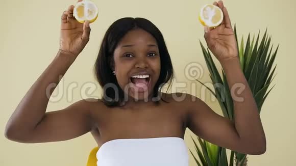 美丽的非洲女人玩两片柠檬青春和护肤用水果天然化妆品视频的预览图