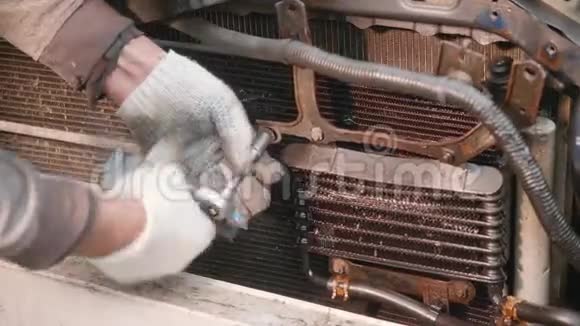 男的双手戴着白手套解开了自动变速器的坏散热器视频的预览图