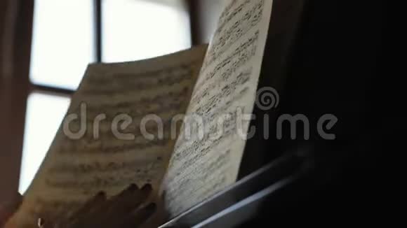 钢琴家的女孩在缓慢的动作中翻阅音符视频的预览图