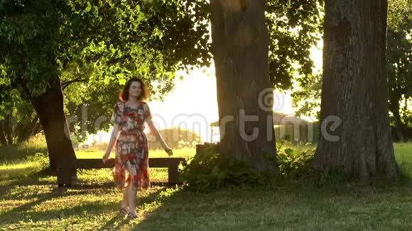 快乐的女孩在夕阳下在公园里跳慢镜头视频的预览图