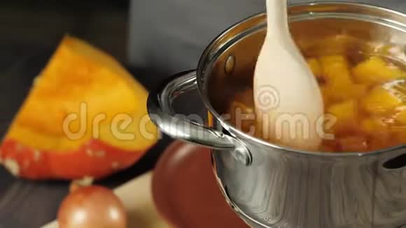 奶油南瓜汤烹饪搅拌着一小块南瓜用平底锅煮快关门4K视频的预览图