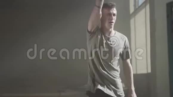 一个穿着破t恤的男人在废弃的大楼里跳嘻哈舞排练视频的预览图