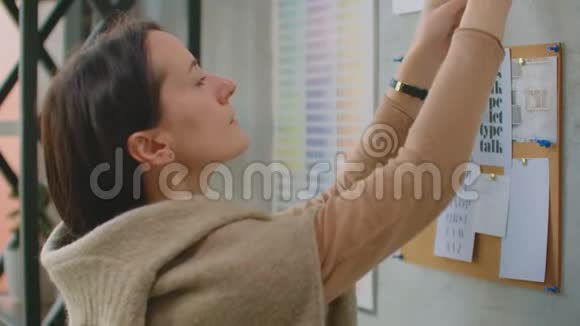 年轻的女色彩设计师站在墙边挑选颜色看素描花墙视频的预览图
