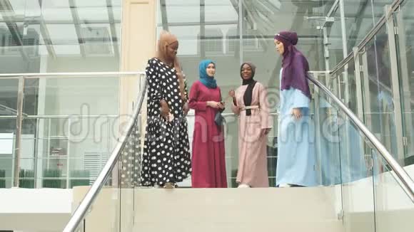四个穆斯林女孩在购物中心的楼梯上散步视频的预览图