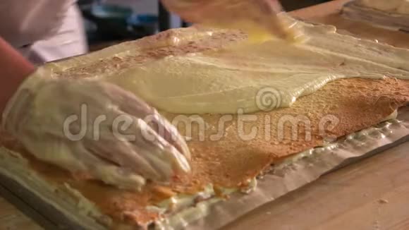 厨师用手涂抹分层蛋糕和奶油视频的预览图