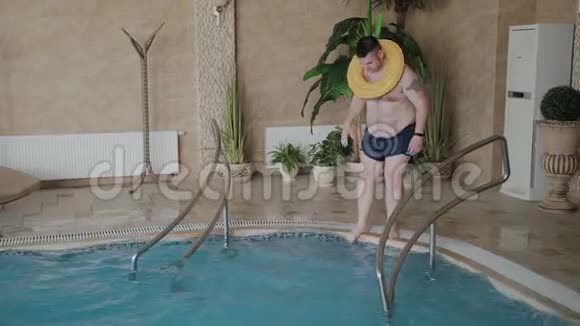 开朗的男人在游泳池里用充气圈游泳视频的预览图