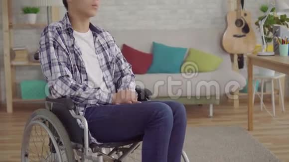 厌倦了无聊的亚洲年轻人在家里坐轮椅视频的预览图