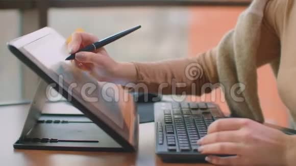 办公室里的一位专业设计师在办公室里坐着一个巨大的窗户在平板电脑上用手写笔画画视频的预览图