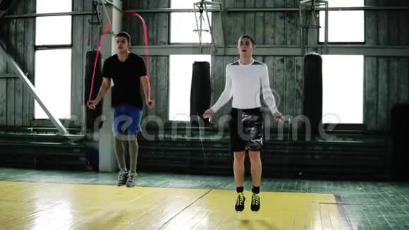 年轻的拳击手穿着休闲服装在拳击工作室健身房里用跳绳跳跃做跳高运动视频的预览图