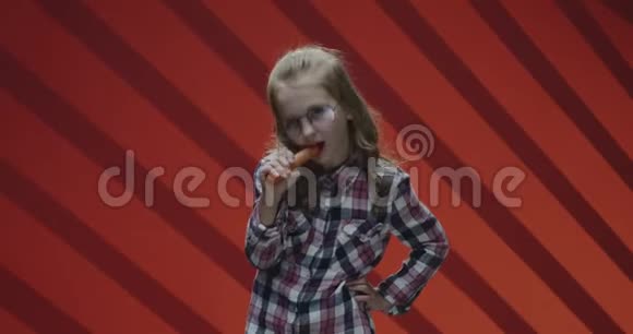 女孩吃胡萝卜对着镜头微笑视频的预览图