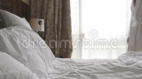 穿浴袍的年轻人睡在公寓的床上视频的预览图
