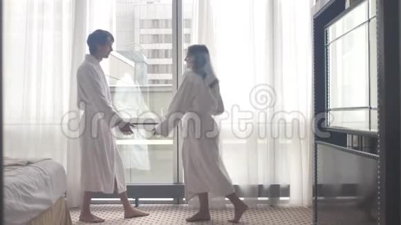 到达酒店后年轻迷人的情侣穿着浴袍跳舞视频的预览图