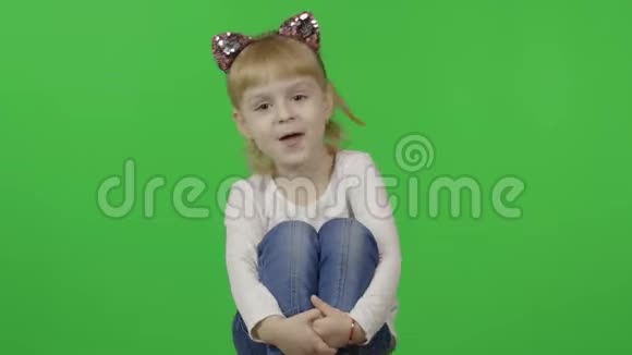 穿牛仔裤和带猫耳朵的头巾的女孩快乐的四岁孩子铬视频的预览图