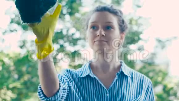 女伴穿着衬衫擦着玻璃和蓝色湿布视频的预览图
