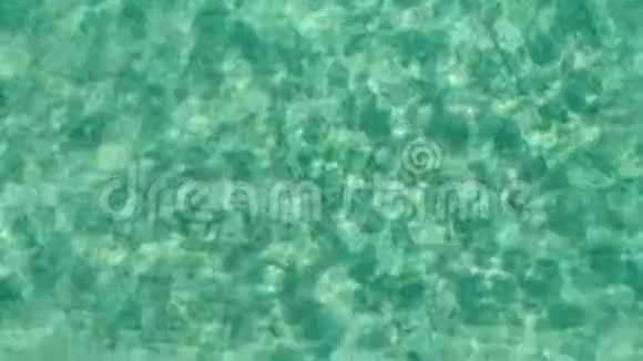 在蓝色海水中漂浮的雄性游泳者上面的无人机绿色海洋视频的预览图