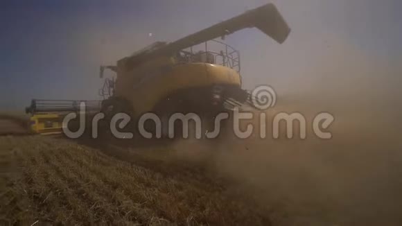 收割机后面的中弹收割机在田里收割小麦希望收获丰厚慢动作视频的预览图