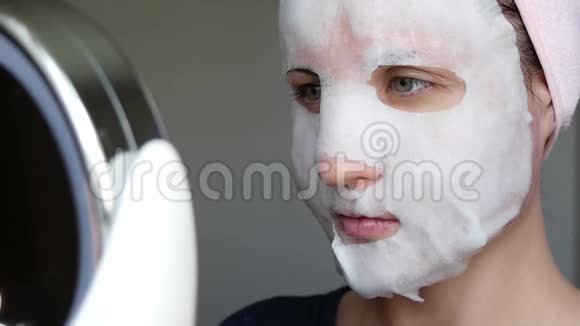 一个戴着化妆面具的女人看着镜子里的自己美容理念问题肌肤抗衰美容视频的预览图