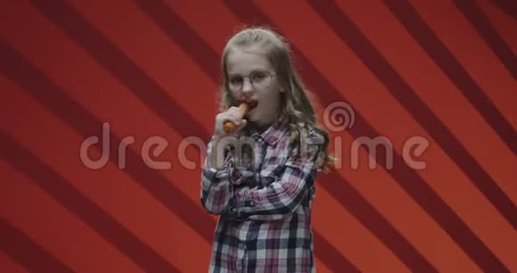 女孩吃胡萝卜对着镜头微笑视频的预览图