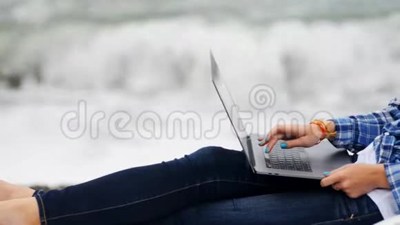 女人坐在蓝色牛仔裤和休闲衬衫与数字技术笔记本电脑设备密切的视野视频的预览图