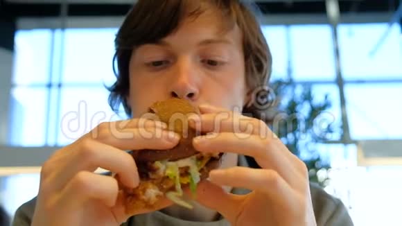 专心致志的家伙拿着汉堡包咀嚼特写镜头视频的预览图