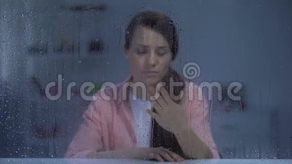 女人在雨窗后摘下订婚戒指分手后心烦意乱视频的预览图