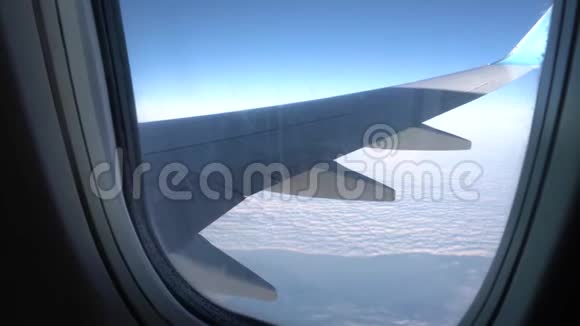 从平面窗口查看飞机窗口的翅膀和天空视频的预览图