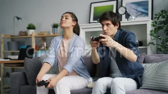 快乐的一对夫妇在家玩电子游戏玩得开心休闲放松视频的预览图