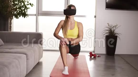 性感的女孩完美的肌肉身体戴着VR面具在她的家庭工作在客厅戴着面具的女孩视频的预览图