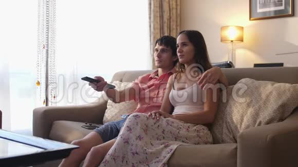 有魅力的夫妇在客厅里放松和看电视视频的预览图