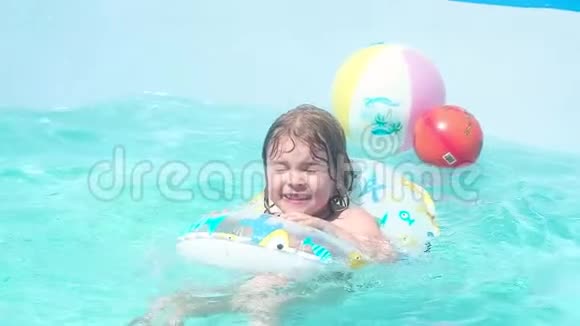 小女孩在游泳池里孩子们的充气圈里游泳快乐地笑着视频的预览图