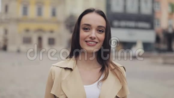 美丽的年轻女士站在城市背景的近旁开心而轻松地微笑和欢笑视频的预览图