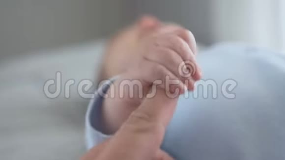 睡婴儿手轻轻握住成人手指视频的预览图