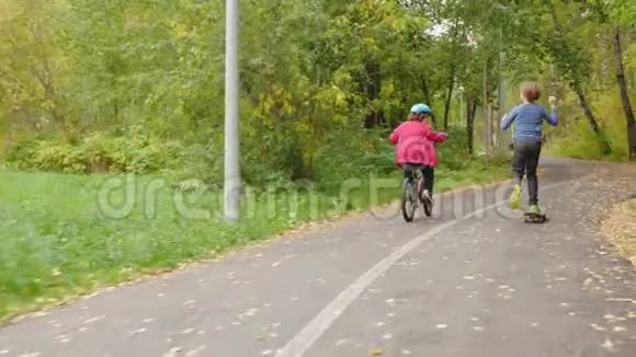 公园儿童骑自行车和滑板的后景视频的预览图