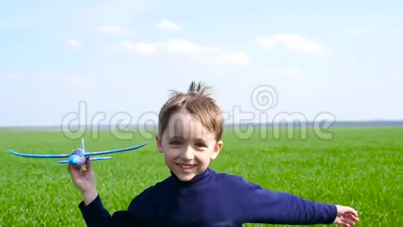 快乐的小男孩在草地上玩飞机视频的预览图