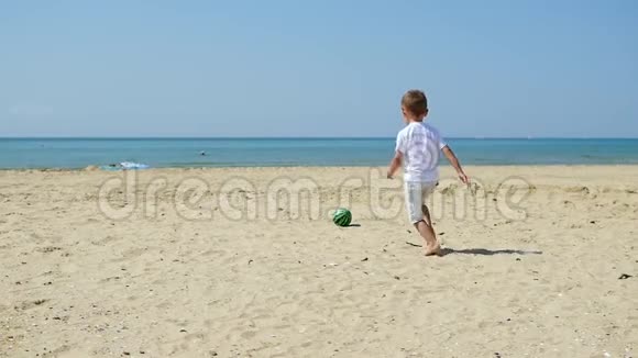 在日落的背景下父亲和儿子一起在海滩上踢球视频的预览图