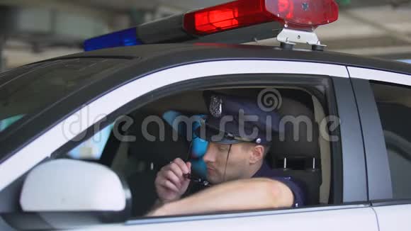 年轻的警察在车里戴着太阳镜对着镜头微笑这是一项重要的工作视频的预览图