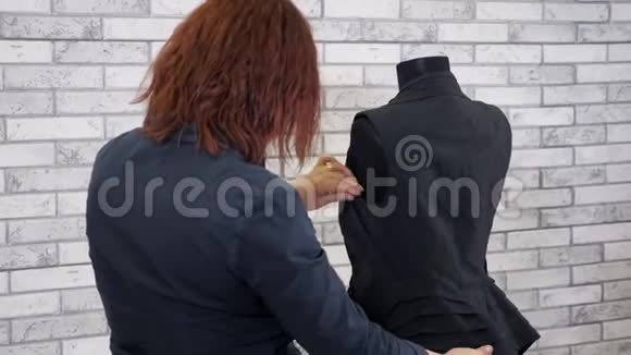 女时装设计师在人体模型上检查新衣服看背心的接缝视频的预览图