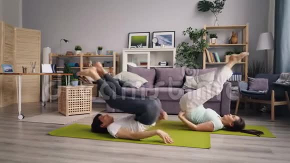 运动情侣在家锻炼一起练习瑜伽练习倒体式视频的预览图