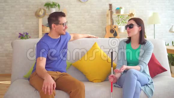 青年男子与坐在沙发上的残疾盲人妇女交流视频的预览图