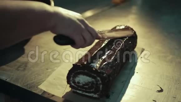手与抹刀正在传播巧克力可可奶油瑞士卷视频的预览图