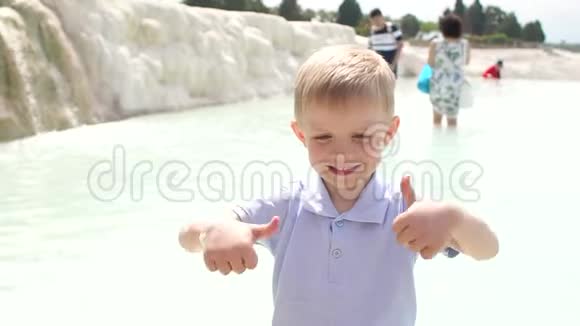 小男孩在帕穆凯尔的石灰华游泳池和露台上玩温水视频的预览图