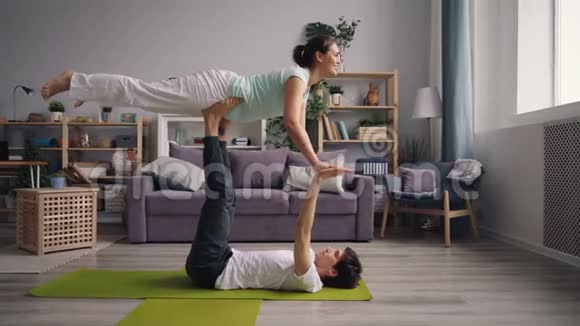 女孩和男人一起练习瑜伽为夫妻做平衡运动视频的预览图