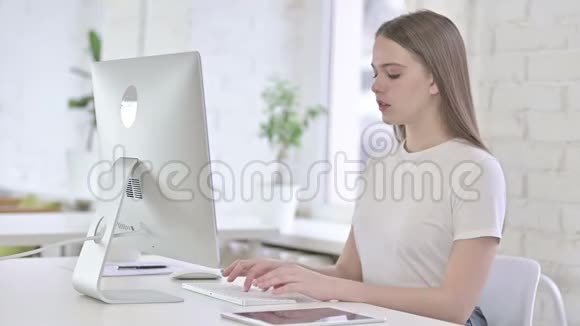 疲惫的年轻女子在办公室里背痛视频的预览图