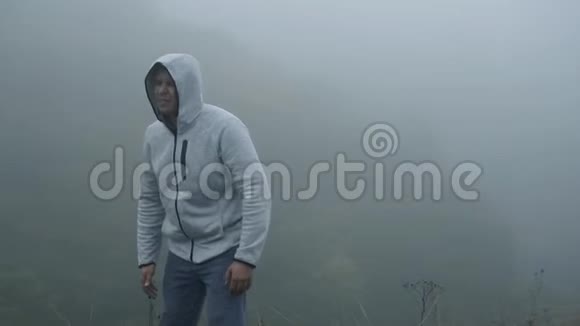 沮丧沮丧的沮丧沮丧的沮丧的人抓住他的头独自站在雾中视频的预览图