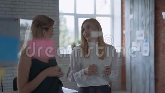两个成功的快乐商业伙伴在办公室的午休时间交流和欢笑女人喝咖啡视频的预览图