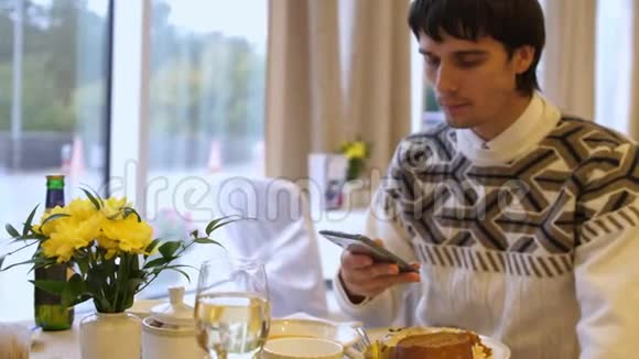年轻人在餐馆吃饭时使用手机视频的预览图