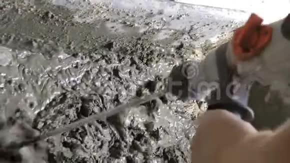 一个人用带有喷嘴的钻头将水与水泥和沙子混合视频的预览图